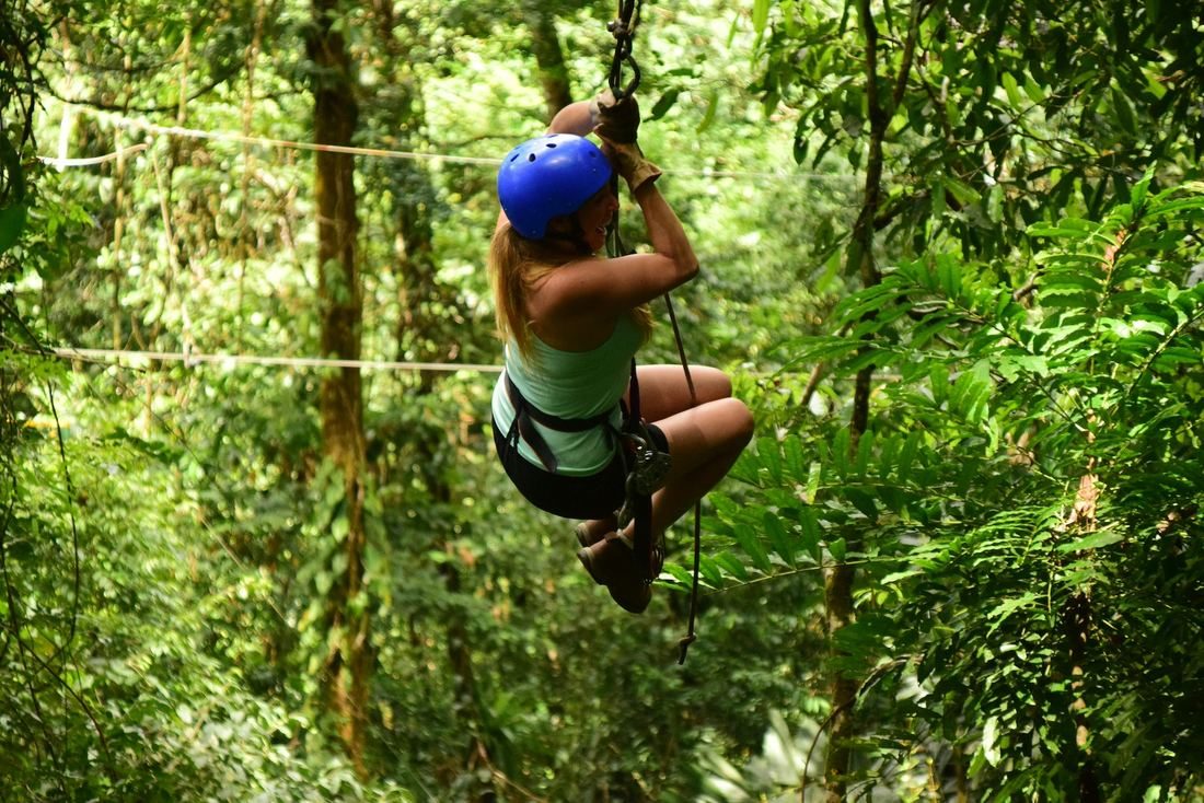 Woman ziplining through the rainforest canopy